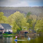 Paddle boarding on the lake with mountains in background Paddle boarding on the lake with mountains in background