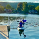 Paddle boarding on the lake by dock Paddle boarding on the lake by dock
